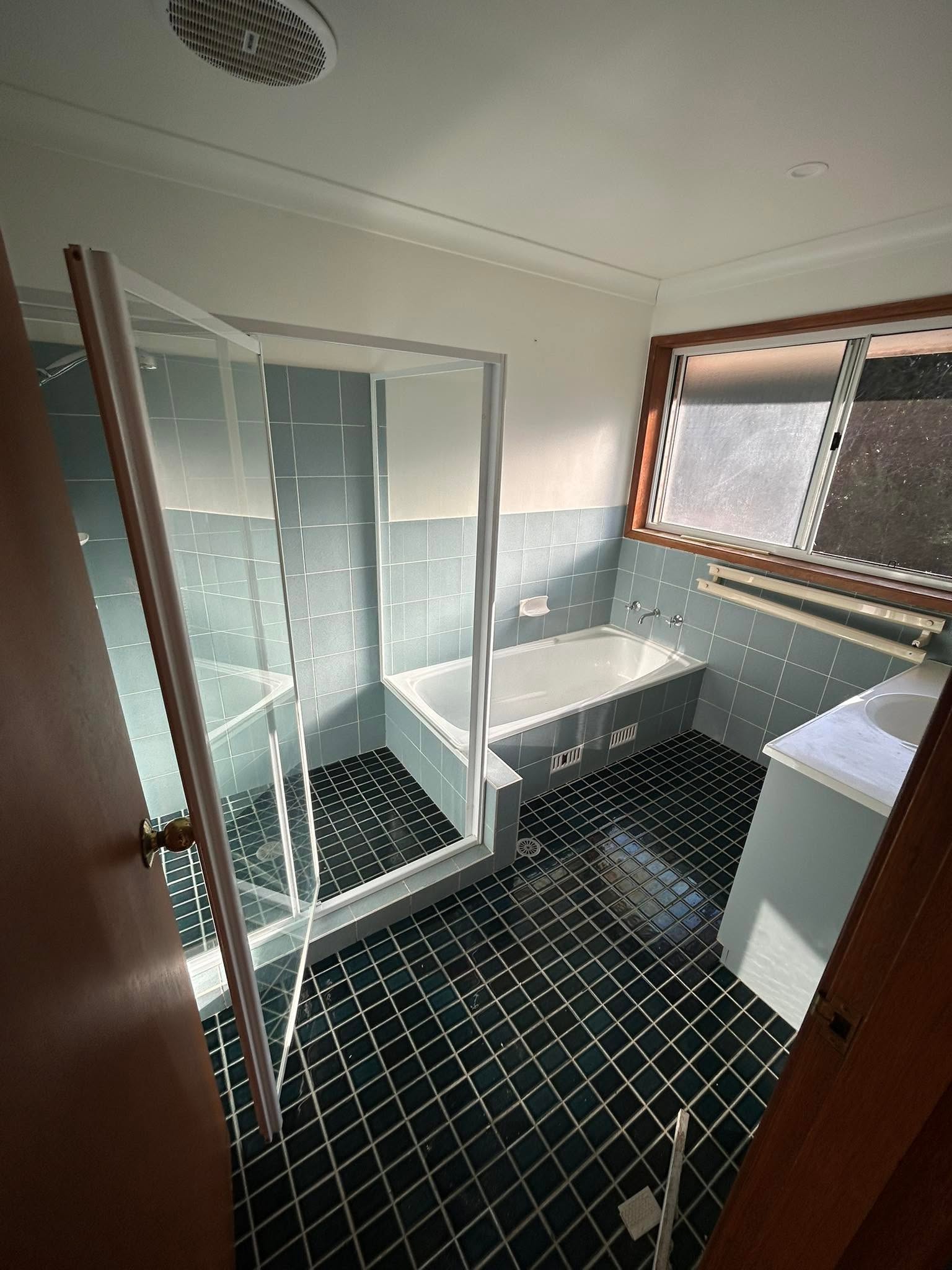Completed bathroom with a vanity, shower and finished plumbing fixtures