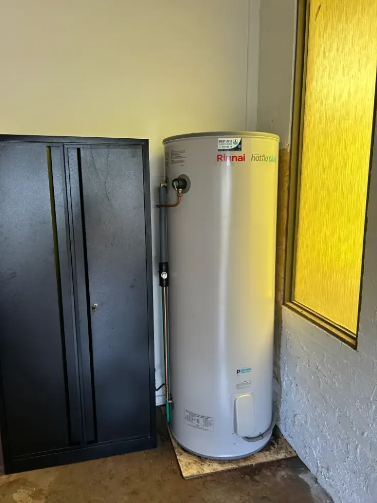 Rinnai hot water cylinder installed indoors beside a window