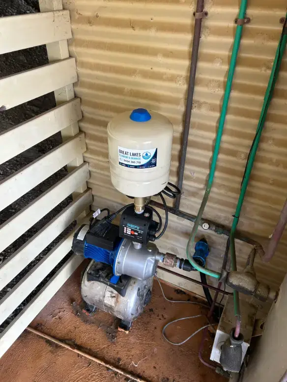 Water pump and pressure tank installed beside an outdoor wall