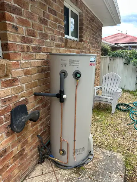Rinnai hot water cylinder installed beside an exterior brick wall